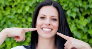 Woman pointing at her beautiful smile